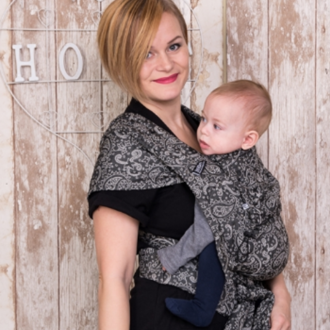 Baby in der Neko Halfbuckle Babytrage Babysize in Efes Paisley Hazel – ergonomisch und flexibel ab Geburt.