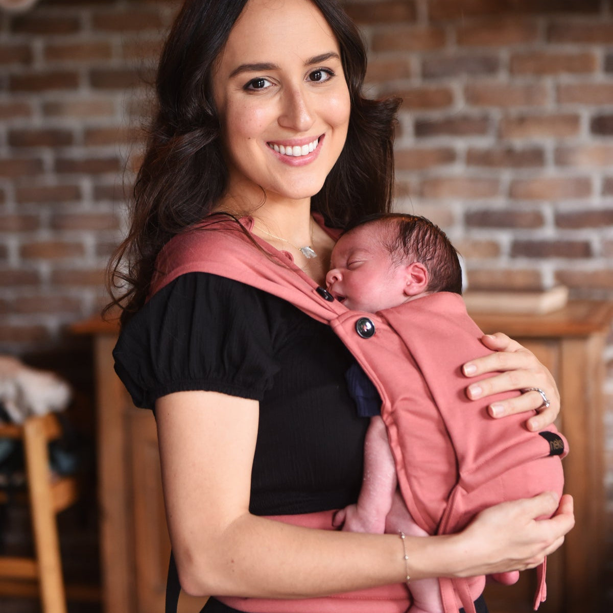 Eltern tragen ihr Neugeborenes in der Neko Tiny Babytrage in Aragon – sanft, ergonomisch und anschmiegsam.