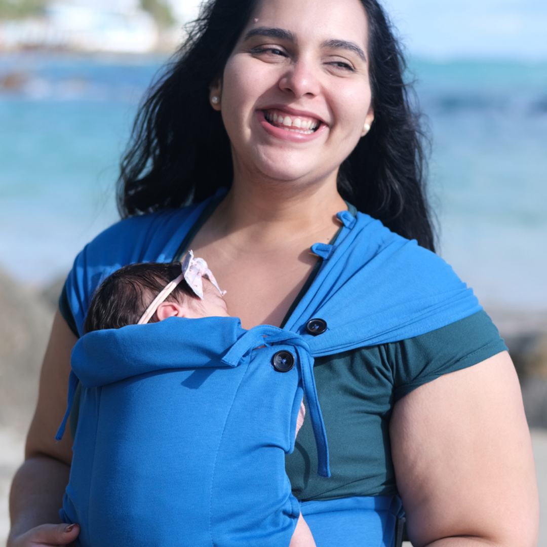Eltern tragen ihr Neugeborenes in der Neko Tiny Babytrage in Cobalt – sanft, ergonomisch und anschmiegsam.